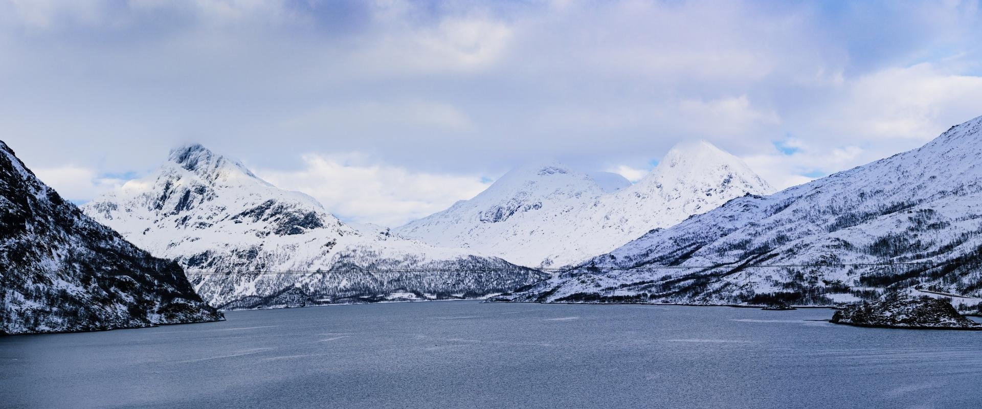 Utsikt over hav og snøbelagte fjell